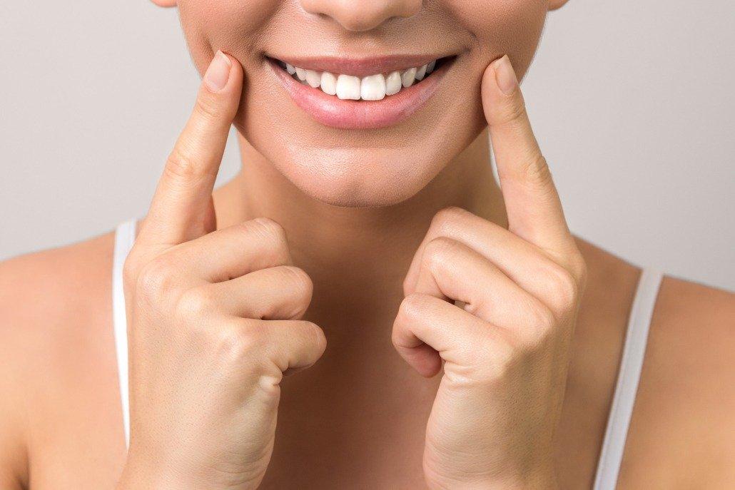 closeup view of female wide cheerful smile with white teeth and clean skin